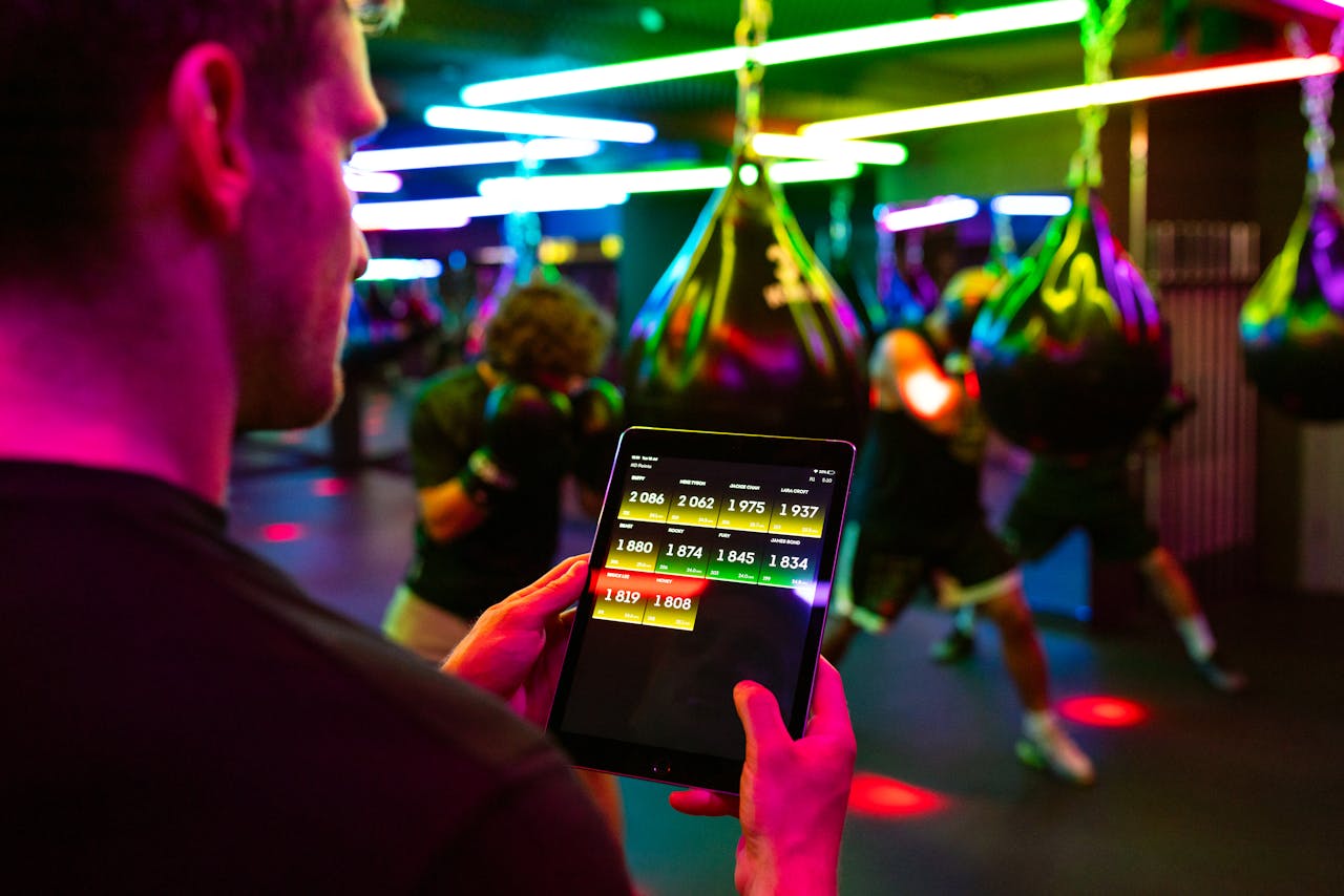 Fitness training in a modern gym with technology for tracking performance on a tablet.